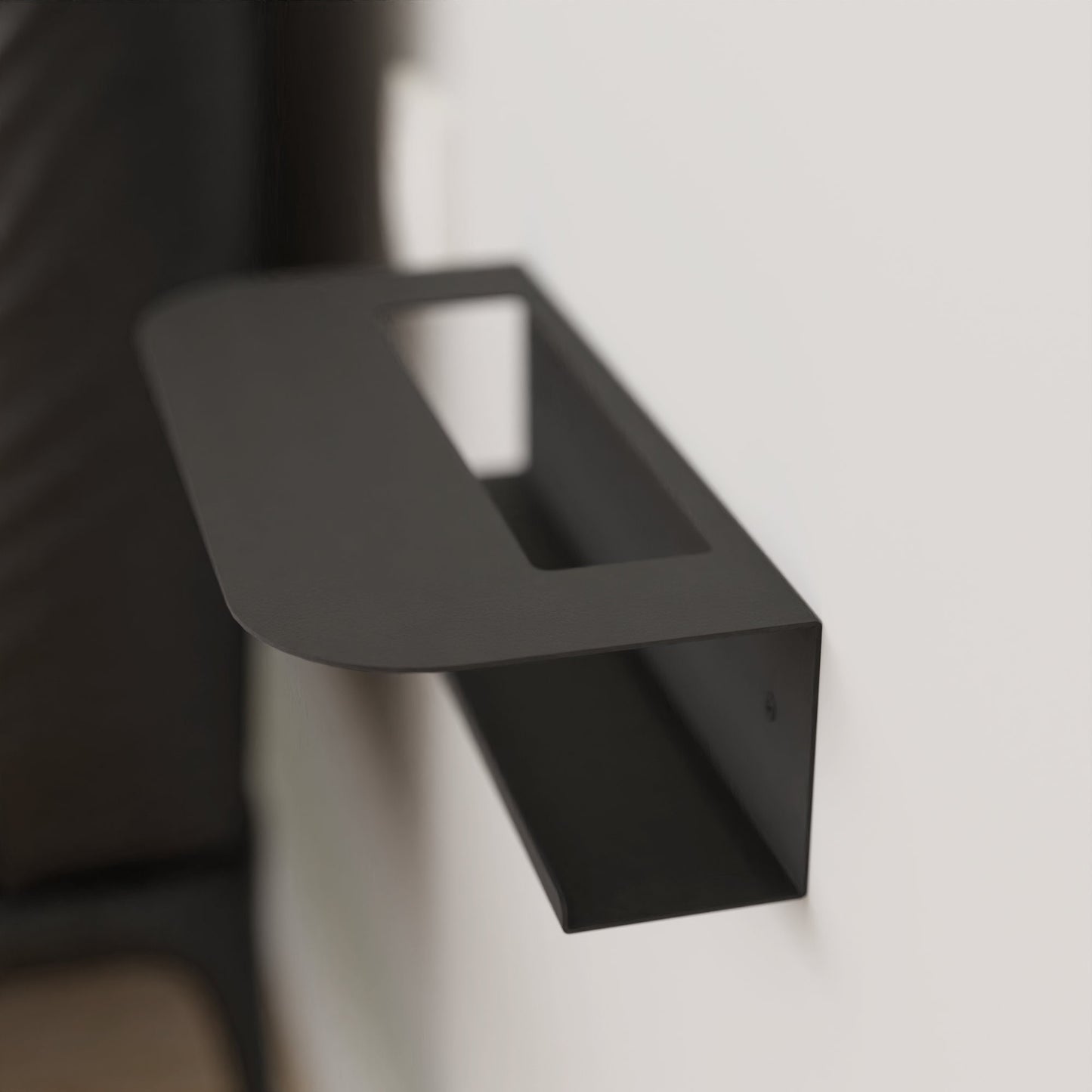 Modern black metal wall shelf holding a glass of water and a book, perfect for minimalist home decor by DnzHomeDesign.