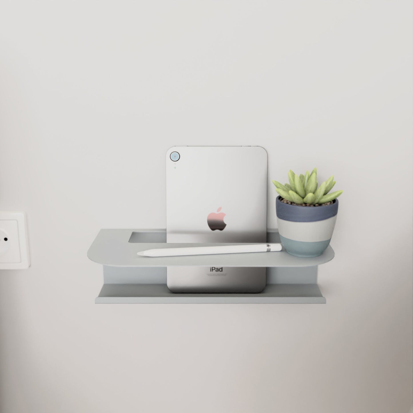 Modern gray metal wall shelf holding a glass of water and a book, perfect for minimalist home decor by DnzHomeDesign.